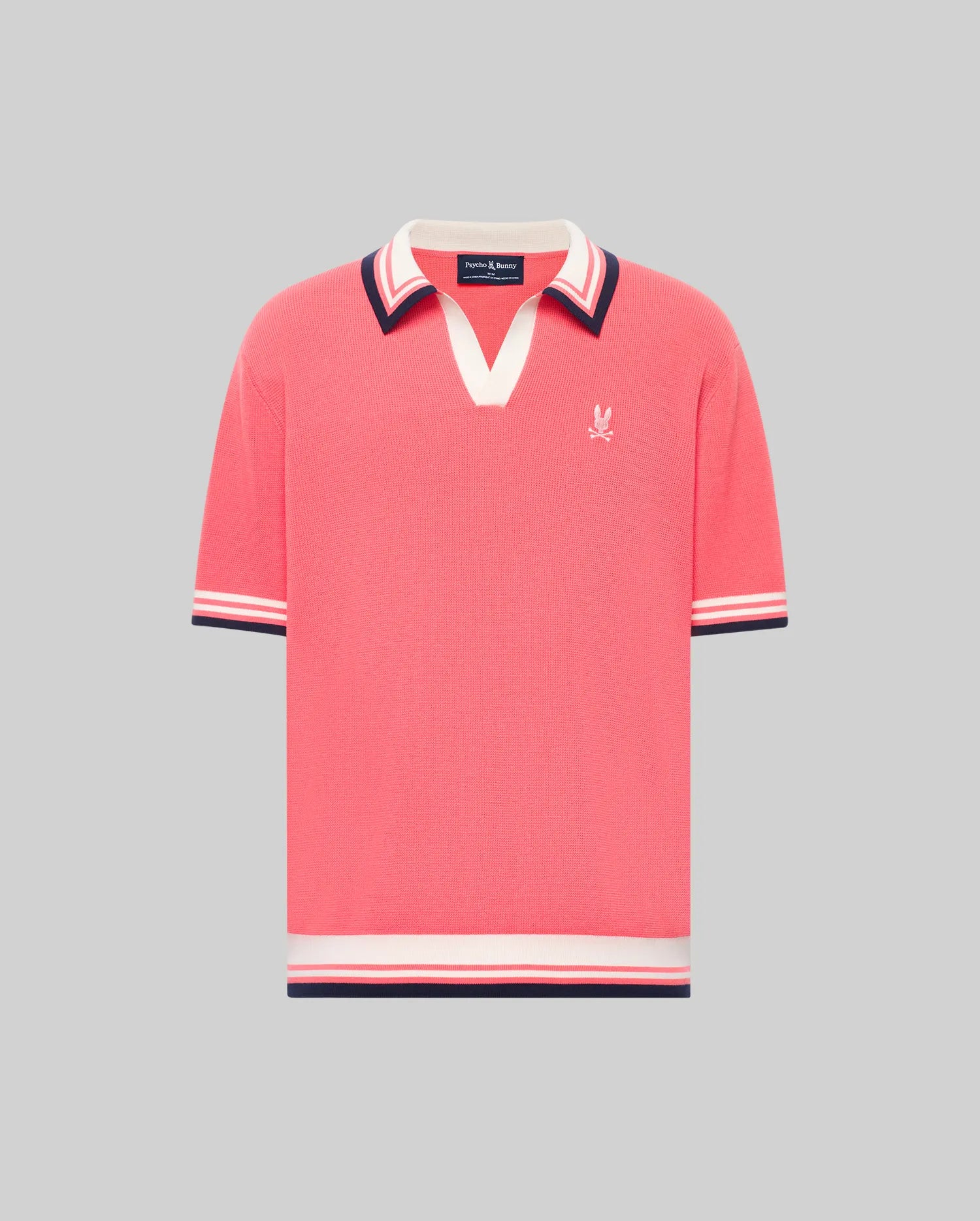 The Psycho Bunny MENS CARTER JOHNNY COLLAR KNIT POLO (MT0400093) is a coral pink, short-sleeved 100% cotton shirt featuring a V-neck Johnny collar, striped cuffs in white, navy, and red, and a small white logo on the left chest.