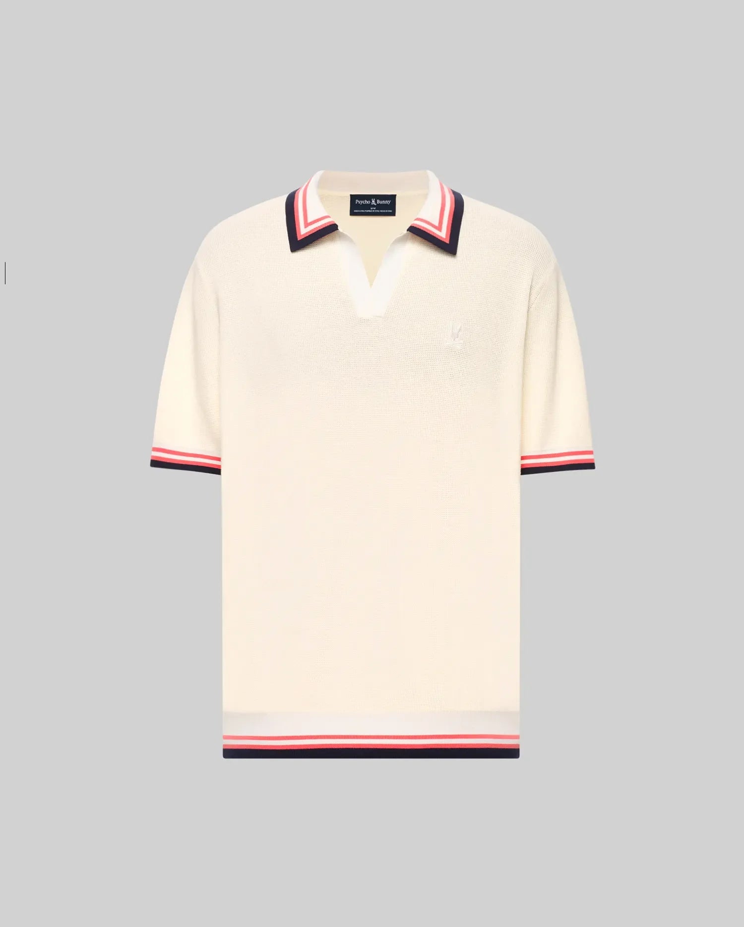 The Psycho Bunny MENS CARTER JOHNNY COLLAR KNIT POLO (MT0400093) is a cream, 100% cotton short-sleeve polo with a deep V-neck Johnny collar and red/navy colorblocked stripes on the collar, sleeves, and hem, shown on a light gray background.