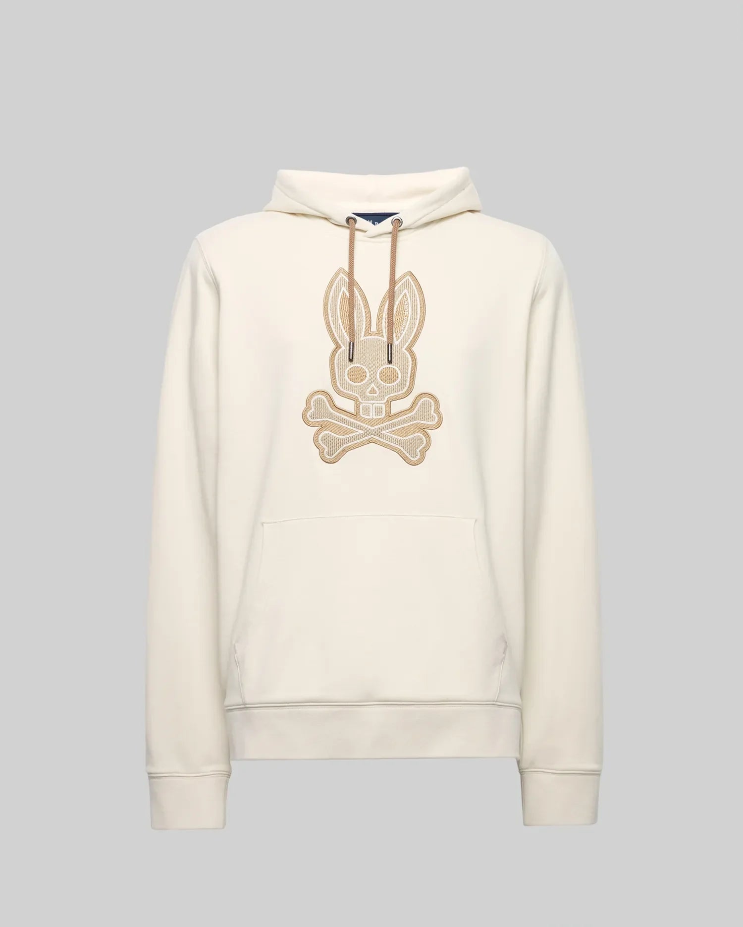 The Psycho Bunny MENS RYDER EMBROIDERED BUNNY PATCH HOODIE (MT0500029) is a cream-colored hoodie with a front pocket, drawstring hood, and large embroidered bunny skull and crossbones patch—ideal for cozy loungewear style.