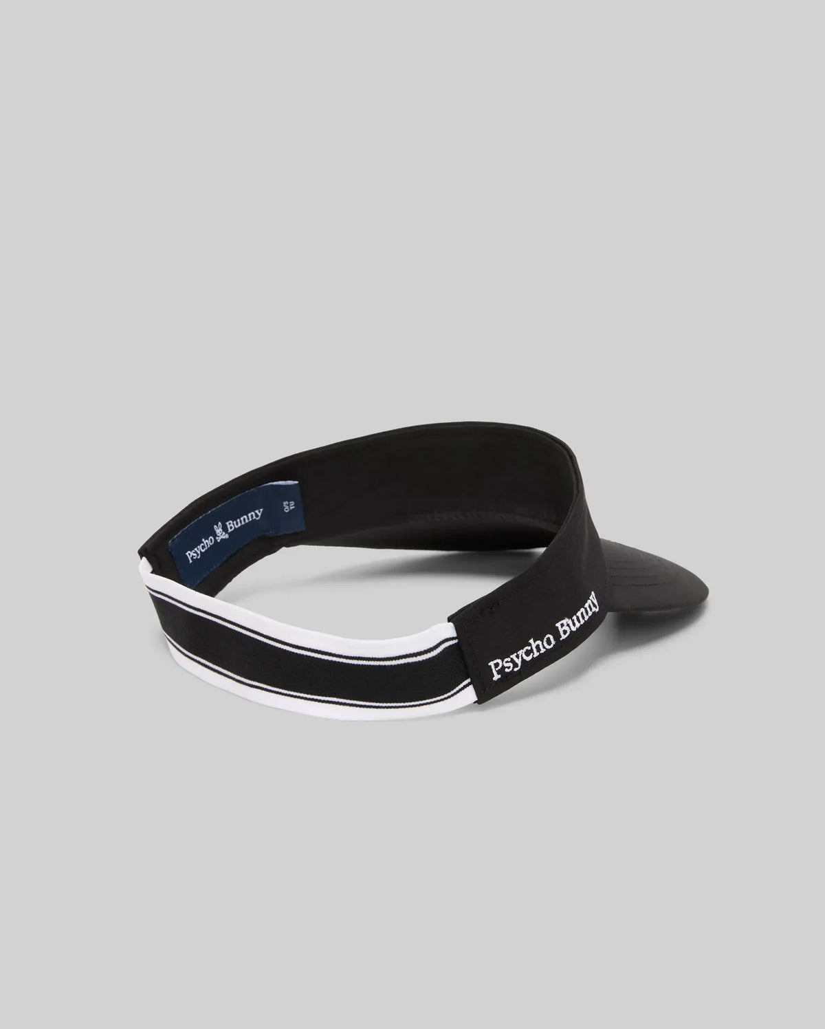 The WOMEN'S SPORT VISOR - WO1500001 by Psycho Bunny features a black design with white trim and "Psycho Bunny" embroidered in white on the side, shown against a plain gray background.
