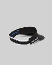 The WOMEN'S SPORT VISOR - WO1500001 by Psycho Bunny features a black design with white trim and "Psycho Bunny" embroidered in white on the side, shown against a plain gray background.