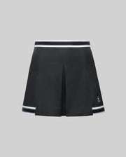 The WOMENS KNIT SKORT - WO1900001 by Psycho Bunny is a black pleated mini skort with white striped trim at the waistband and hem, plus a small white Psycho Bunny logo near the left hem, shown on a plain gray background.