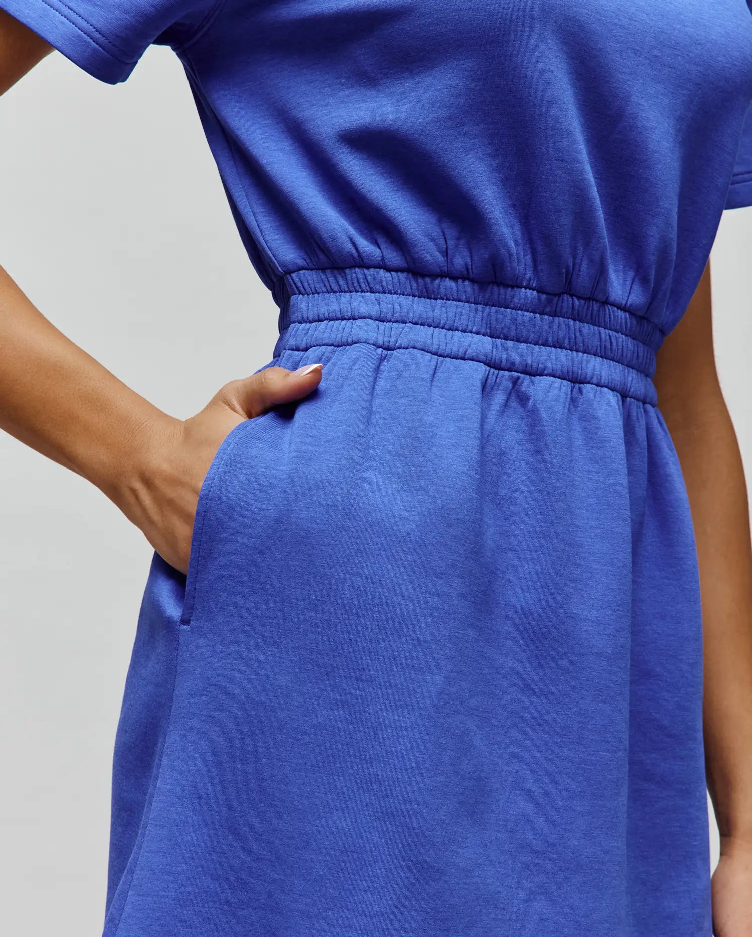 Womens Penelope Dress in vibrant blue soft jersey knit, featuring short sleeves, a relaxed top, cinched elasticated waist, and practical side pockets.