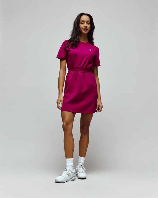 Womens Penelope Dress, a vibrant magenta jersey mini dress with a relaxed fit, crew neck, short sleeves, and an elasticated waist, featuring a small white embroidered Psycho Bunny skull logo on the left chest.