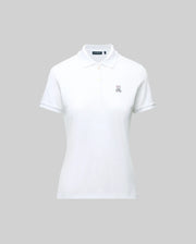 The WOMENS PIQUE POLO - WT0100003 by Psycho Bunny is a white pique polo featuring a collar, buttons, and the embroidered Bunny logo on the left chest. Crafted for Pima flexibility, it is presented against a plain grey background.