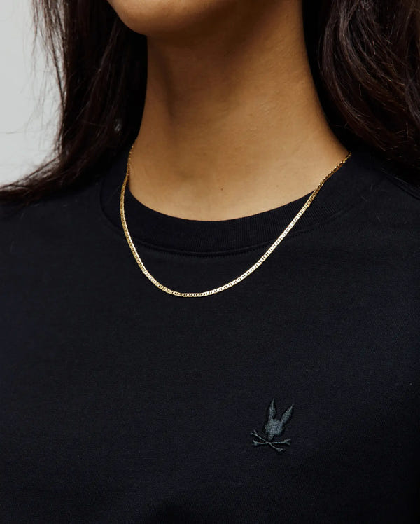 Women's Camille Oversized Fit Tee in premium black jersey knit, showcasing a small, subtly dark grey embroidered Psycho Bunny skull logo on the left chest, embodying refined streetwear.