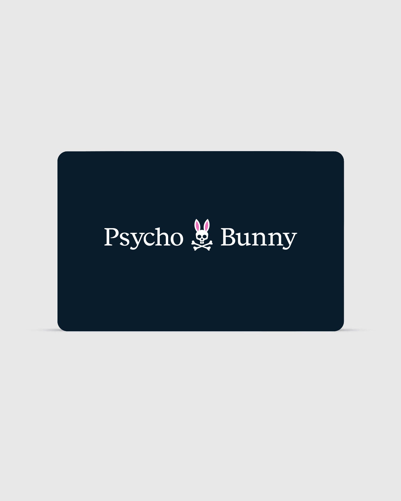 A rectangular card with a dark background features the text "Psycho Bunny Canada" in white. Between the words is a stylized logo of a bunny head with pink ears and a skull and crossbones beneath it. You can check your balance or redeem your Digital Gift Card for exclusive Psycho Bunny apparel using their digital platform.