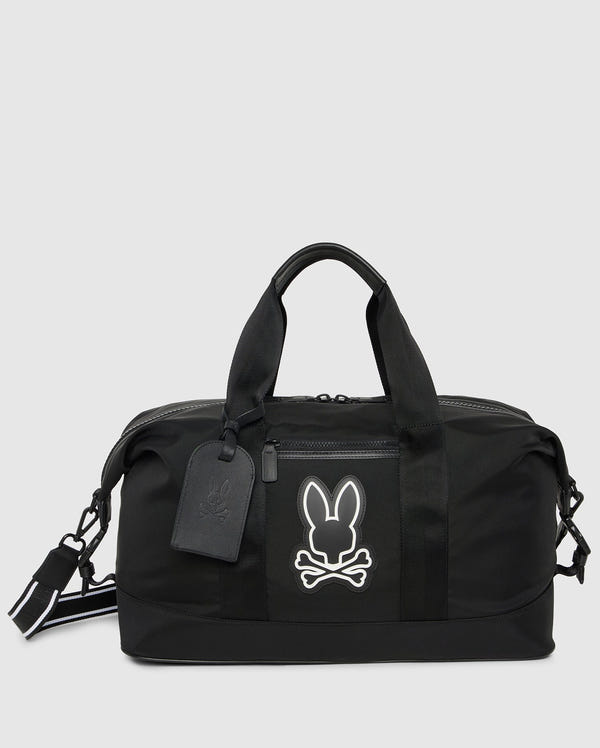 The Psycho Bunny MENS WEEKENDER BAG - B6A629Z1BG is your go-to travel companion with a white rabbit and crossbones logo. It includes dual handles, a detachable strap, luggage tag, zipper closure, and minimalist design—perfect for a weekend getaway.