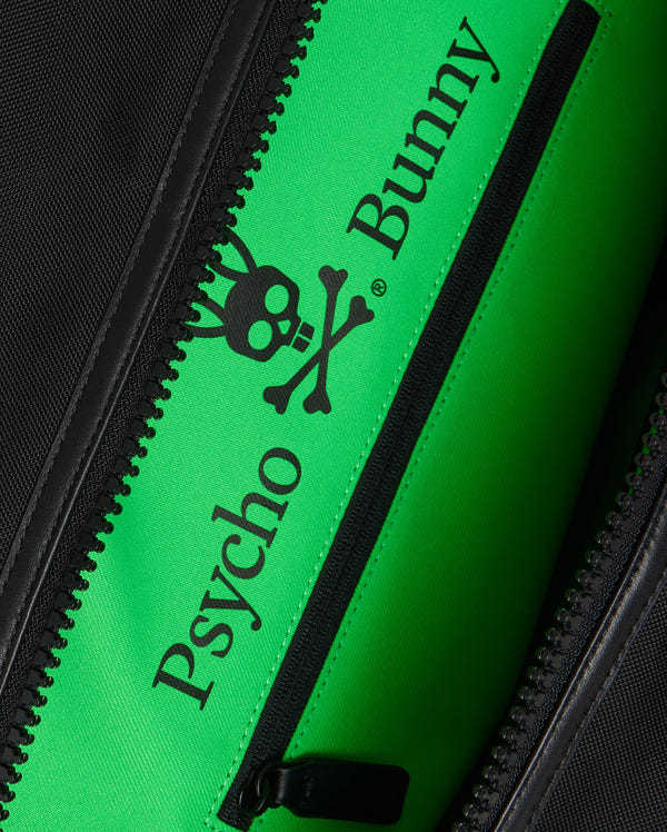 Close-up of a zipper pocket on the stylish MENS WEEKENDER BAG - B6A629Z1BG by Psycho Bunny, showing a bright green interior. The interior sports a stylized bunny skull and crossbones logo with "Psycho Bunny" text in black—an ideal versatile travel companion.