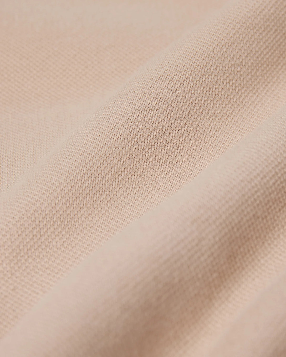 Close-up of a beige fabric with a slightly textured surface, displaying a series of gentle horizontal folds. The material appears soft and smooth, suggesting an elevated style and an exceptional on-body feel, perfect for crafting Psycho Bunny's MENS BEDFORD SHIRT JACKET - B6J290B200.